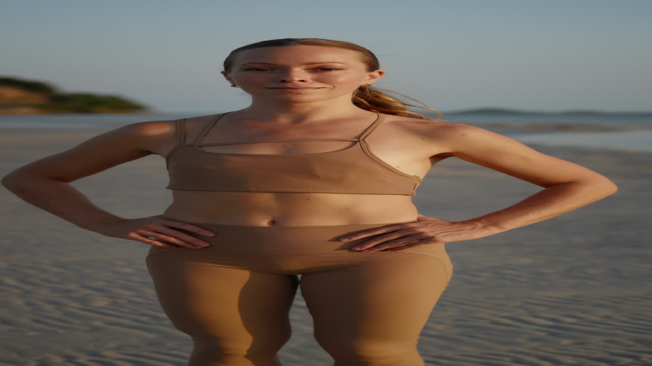 Confident Woman Standing and Smiling on a Sandy Beach