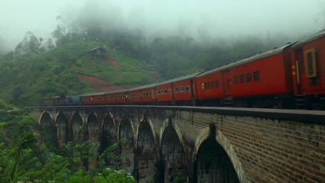 train crossing nine arch bridge at misty morning in ella, sri lanka