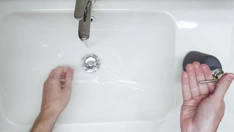 top down shot of a man extensively washing his hands with soap