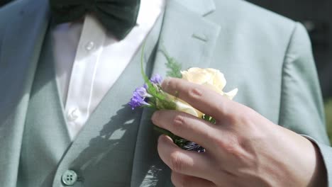 groom putting his flower in his pocket