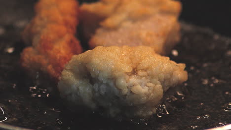 Slow-motion,-close-up-shot-of-frying-frozen-chicken-karage-on-a-pan