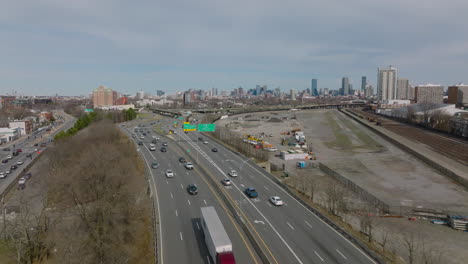 Volar-Por-Encima-De-La-Concurrida-Carretera-Principal-De-Varios-Carriles.-Carretera-Que-Conduce-A-Los-Suburbios,-Edificios-Altos-Del-Centro-A-Lo-Lejos.-Boston,-Estados-Unidos