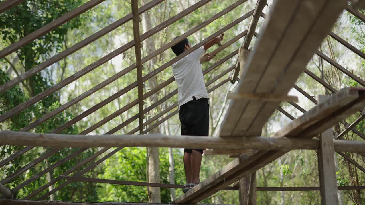 Man constructing a wooden roof frame outdoors