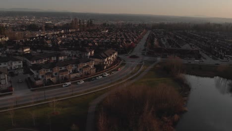 Wide-aerial-view-flying-over-suburban-neighbourhood-filled-with-town-homes-grassy-areas-and-a-footpath