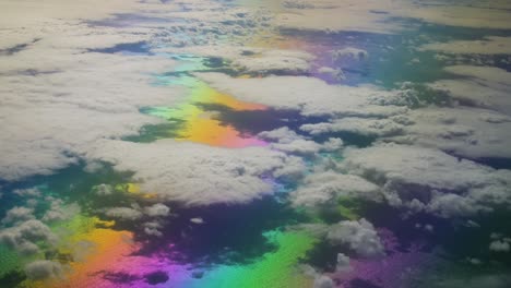 rainbow landscape of an colorful ocean above the clouds with the sea from a airplane travelling the atlantic ocean