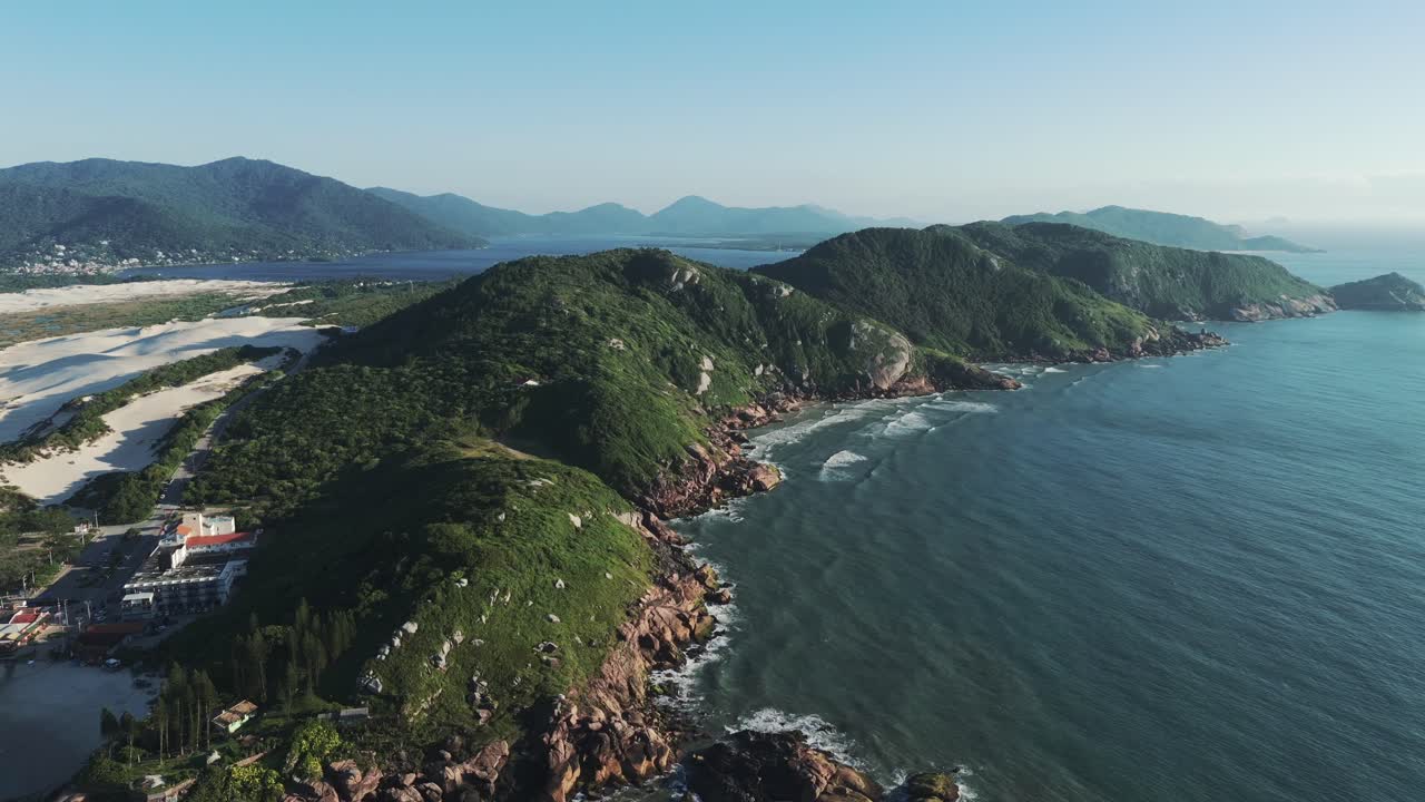hermosas montañas verdes bordean la costa brasileña junto a la famosa playa de joaquina, creando un entorno mágico a lo largo de las orillas del océano atlántico.