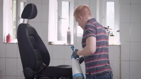 hombre rociando el asiento del coche con pulverizador