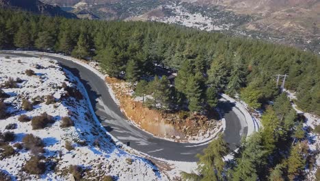 aerial view of a curve in the road in the snowed mountains