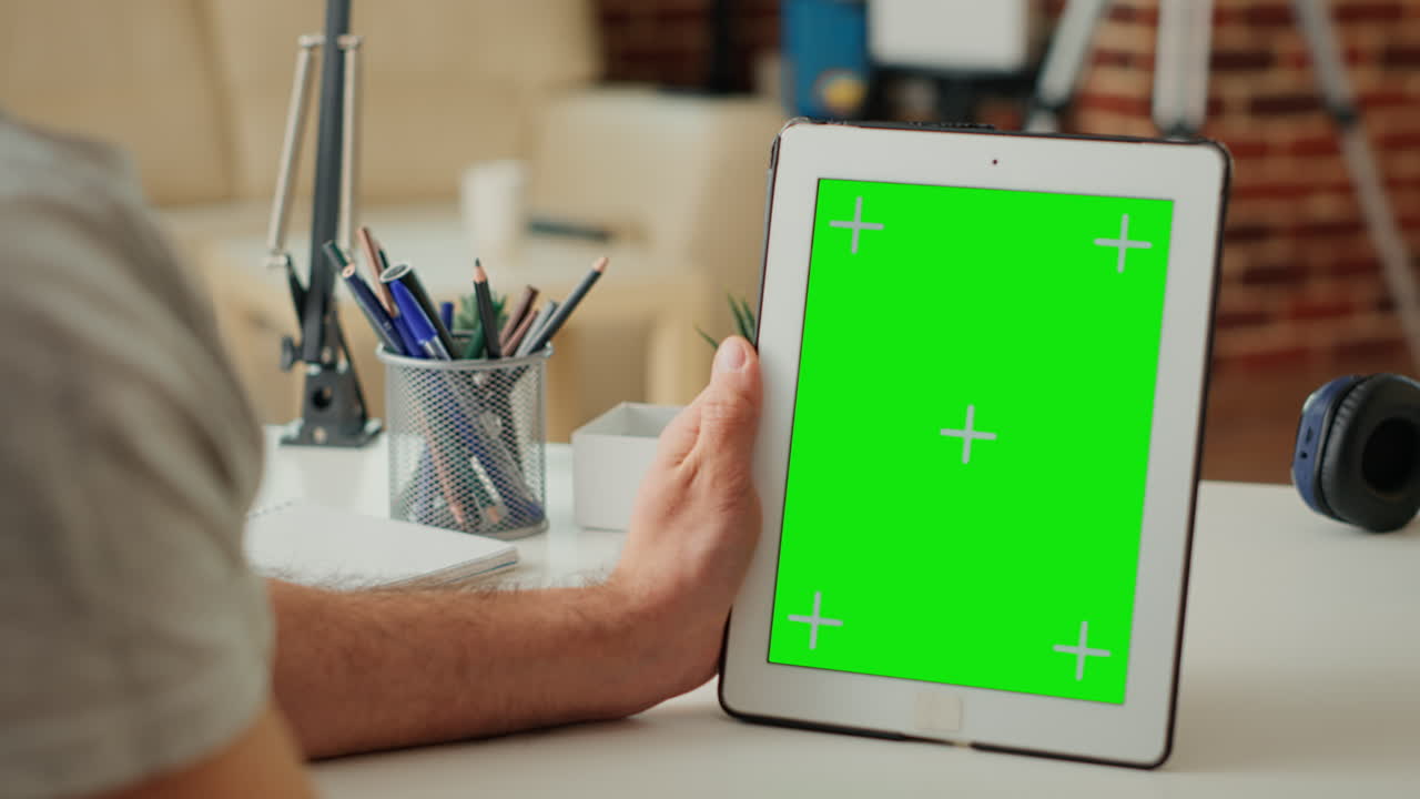 Office worker vertically holding digital device with isolated greenscreen