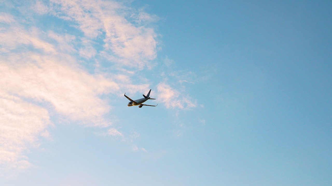 disparo de bajo ángulo, silueta de un avión volando en el cielo azul lejano hacia el destino