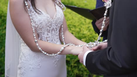 a bride and groom holding hands while getting married in an outdoor religious ceremony