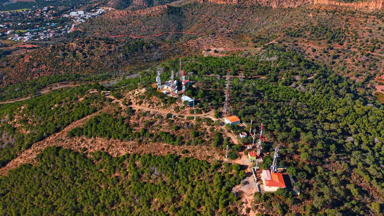 Ilmakuva tietoliikennemastoista metsäisellä vuorenselänteellä. Korkeakulmakuva matkapuhelinmastoista ja radioantenneista metsäisellä mäenhuipulla Espanjassa.