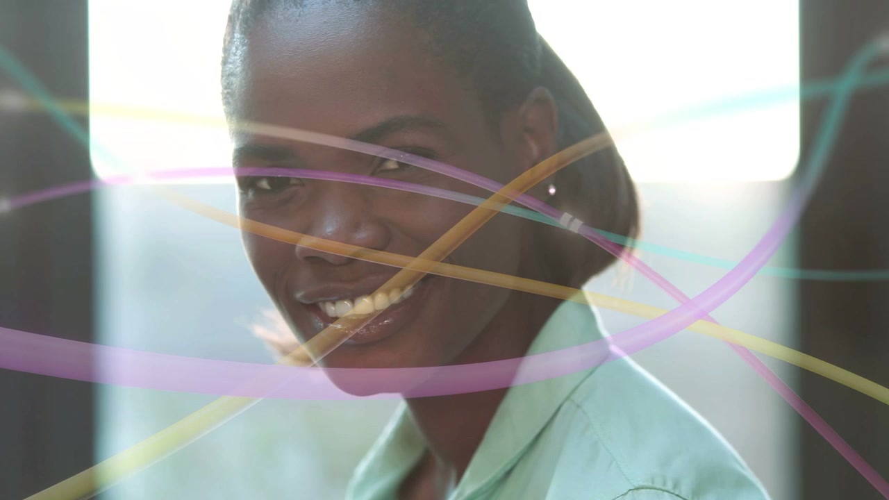 Woman typing laptop causing camera pan, ribbons crossing face, lifting head smiling in tech work