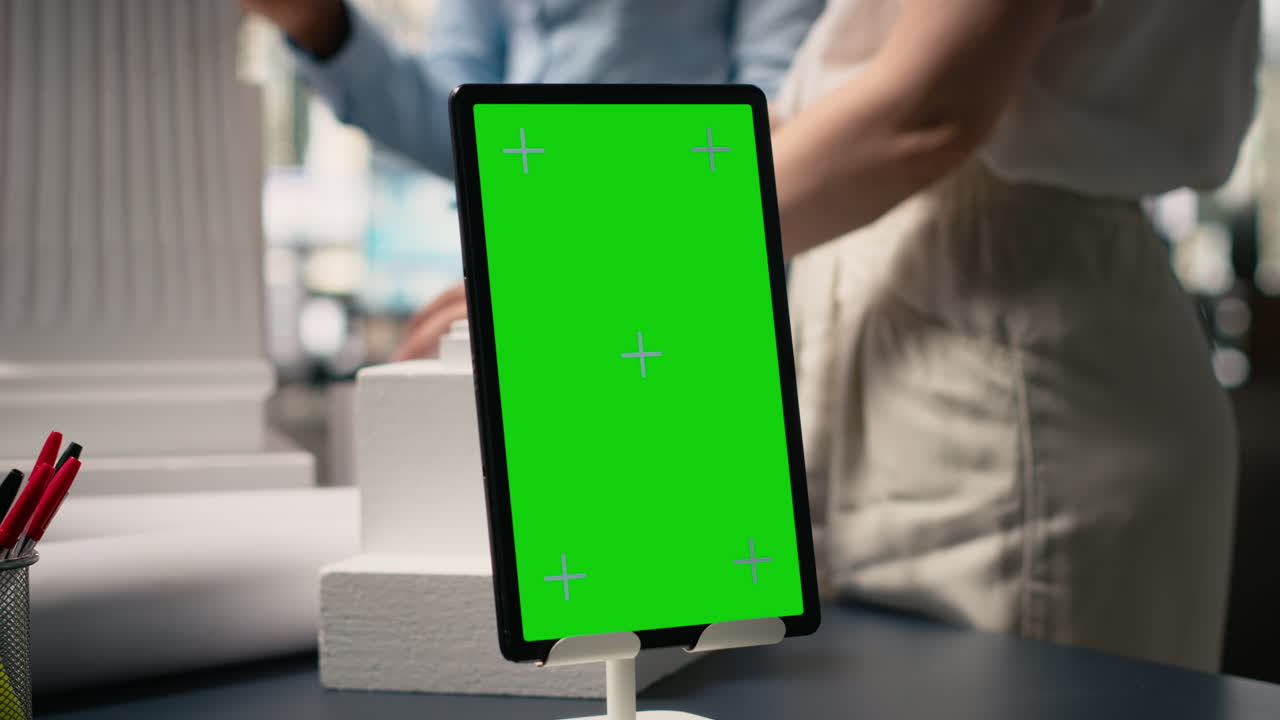 Vertical Video Engineers team share master plan ideas next to chroma key display