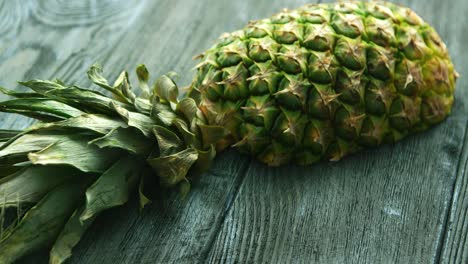 Half-of-pineapple-on-wooden-table