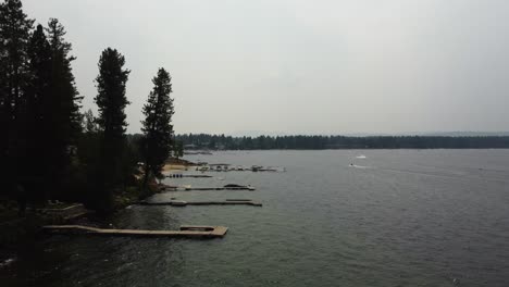 Counterclockwise-drone-shot-of-the-boats-docked-on-the-shore,-revealing-the-town-of-McCall-and-the-rest-of-Payette-Lake