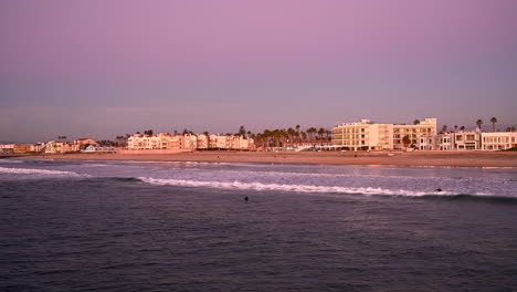 Surfers-surfing-at-sunset-at-Imperial-Beach-California,-San-Diego-county