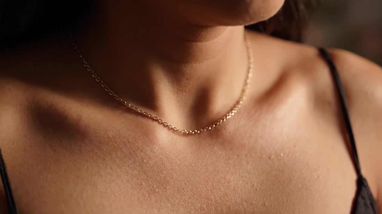 Un primo piano sull'eleganza: la bellezza di gioielli delicati messa in risalto da un'illuminazione soffusa e tonalità naturali della pelle