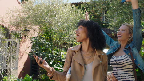 two-woman-friends-arriving-at-hotel-villa-with-trolly-bags-enjoying-summer-vacation-looking-at-beautiful-country-house-excited-for-holiday-4k-footage