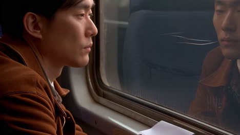 a man looking out a train window