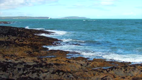 Medium-to-wide-shot-of-waves-was-they-violently-crash-on-rocks-on-the-Irish-coastline