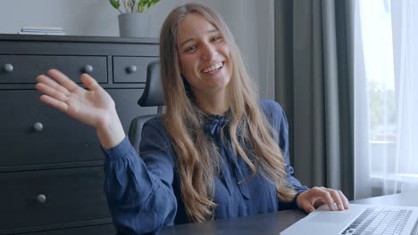 young female worker waving and smiling in the office, in slow motion