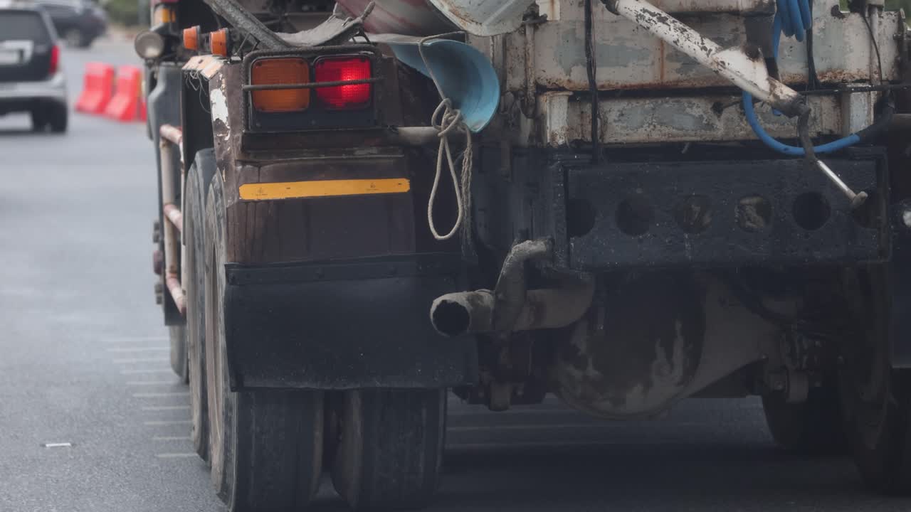 un camión emite gases de escape en una concurrida carretera de phuket. la iluminación nublada destaca la contaminación urbana y la congestión del tráfico