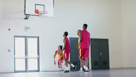 african american man watches as a young african american man scores a basket