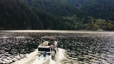 drone shot following boat in indian arm, an ocean in vancouver, canada