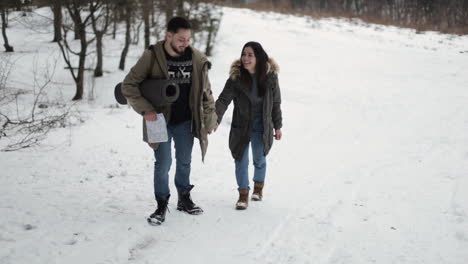 caucasian couple hiking on a snowed forest.