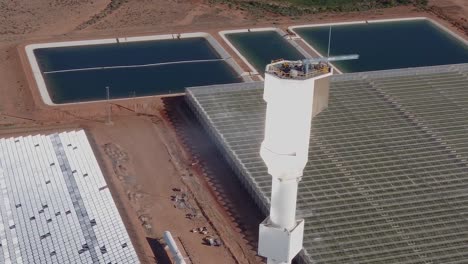 una vista aérea de una granja de energía solar térmica con miles de espejos que reflejan la luz solar en una torre central donde se convierte en calor y se utiliza para generar electricidad