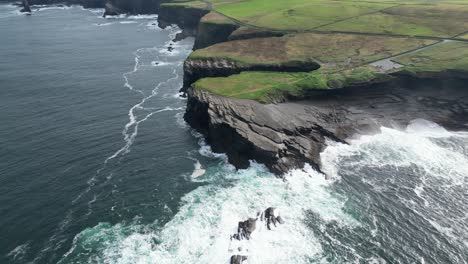 aerial drone shot of the coastal kilkee cliffs in the countryside fields of ireland in county clare along the wild atlantic way