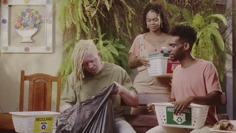 People actively sorting trash into recycling bins for metal, glass, and plastic, demonstrating environmental responsibility
