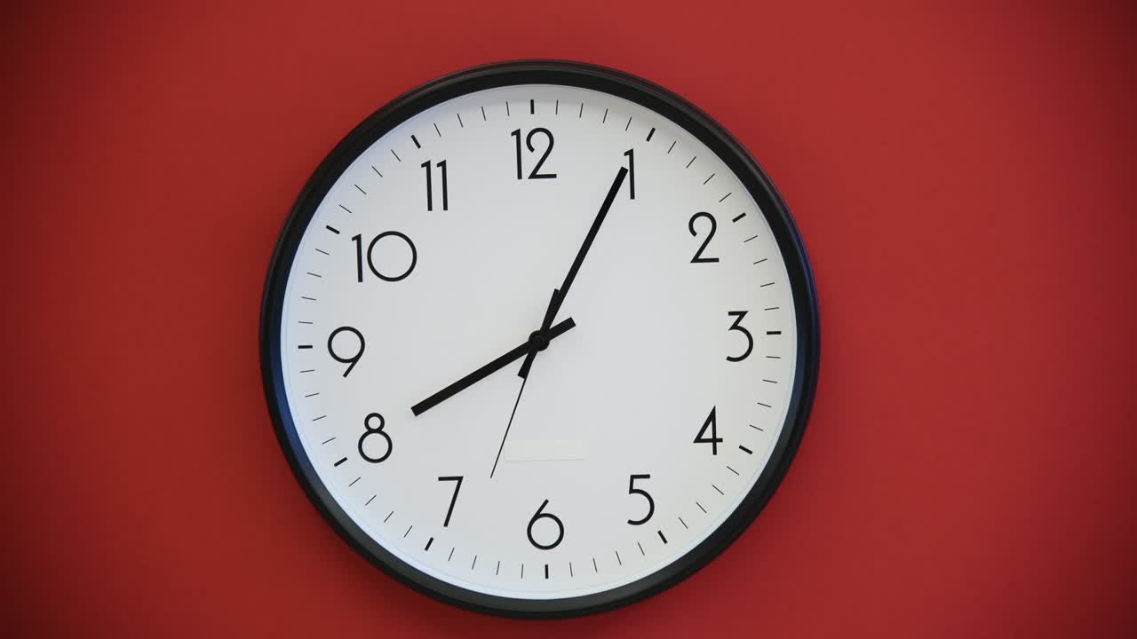 Black wall clock on red background