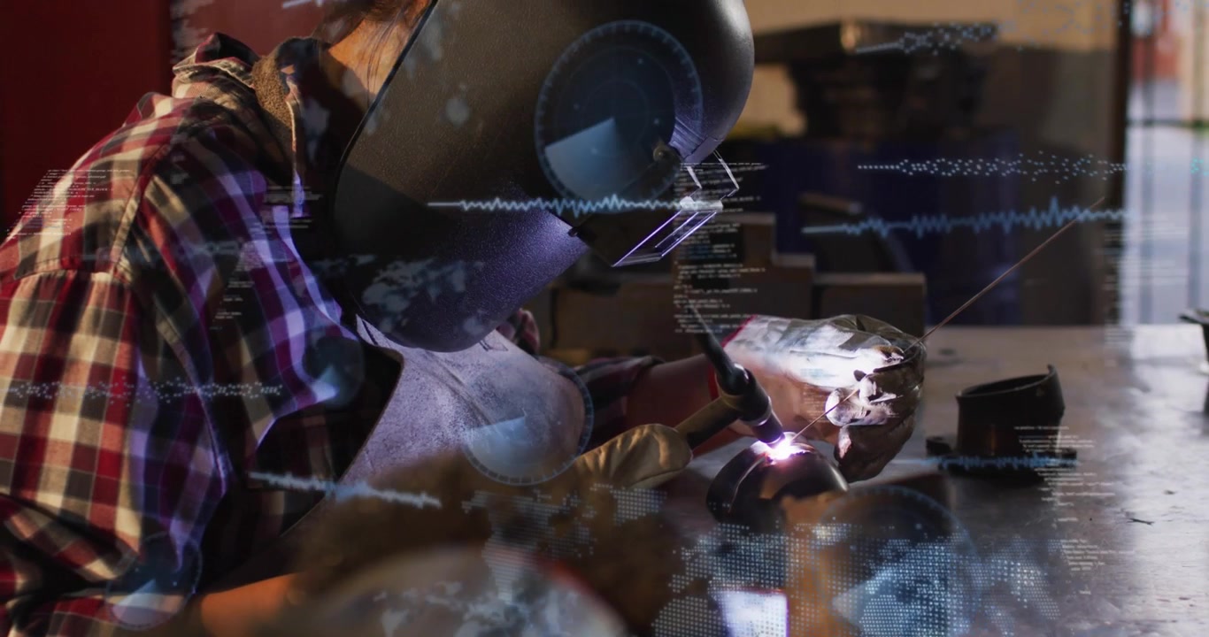Female welder starting welding arc in metal workshop, causing HUD overlays and joining metal part