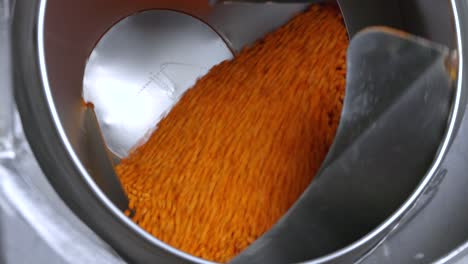 close up shot of a spinning machine mixing beer nuts