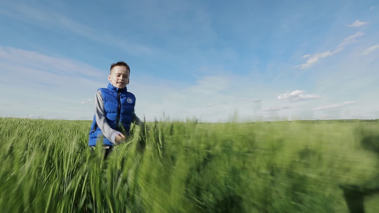 Little Boy Running On The Grass. Little boy running down a meadow in a beautiful landscape in summer
