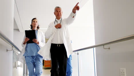 Doctors-and-nurse-running-in-passageway-of-hospital