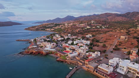 scenic coastal village in greece with calm waters and mountainous backdrop