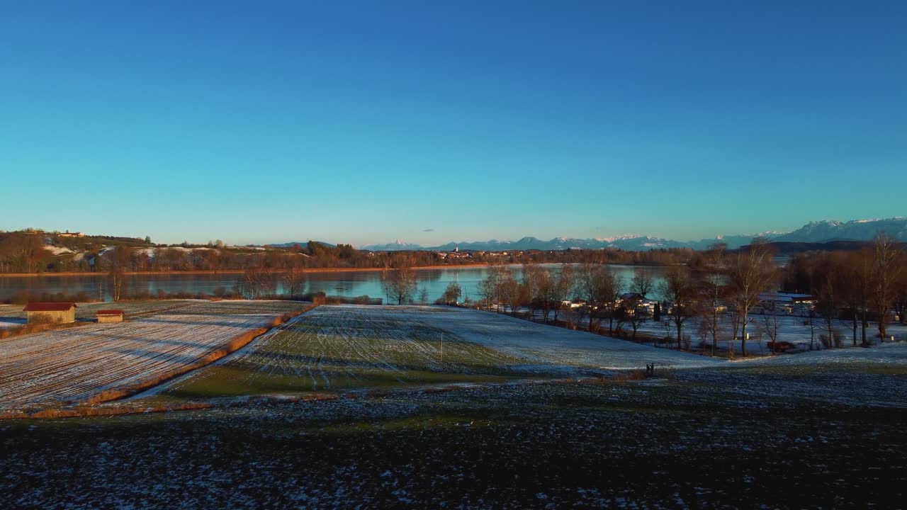 4k uhd 공중 드론은 얼어붙은 얼어붙은 호수를 향해 비행하고 오스트리아 근처 독일의 겨울에 알프스 근처 바이에른의 나무를 통과합니다.