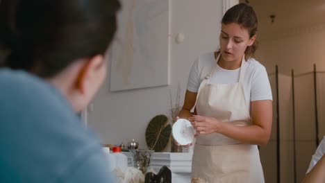 woman presenting a ceramic plate at a workshop