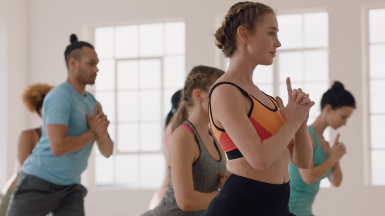 clase de yoga de jóvenes multiétnicos practicando pose de guerrero disfrutando de un estilo de vida saludable instructor de fitness guiando el ejercicio de meditación en el estudio