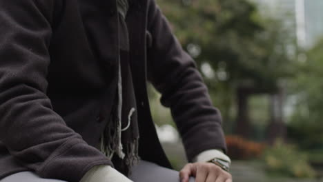 a sad, depressed and worried man sitting on a bench in a park alone, rubbing his forehead, stare lifelessly into the ground, submerged in thoughts