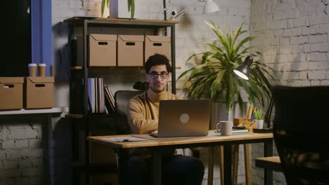 hombre trabajando tarde en la oficina de casa por la noche.