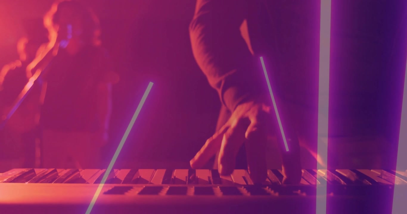 Dita che premono i tasti creando scie al neon, tastierista uomo che suona musica, compagno di band che si muove