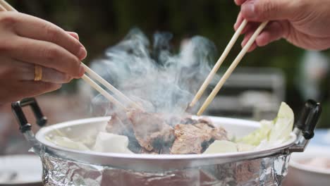 using chopsticks for bbq grilled pork or moo kra ta