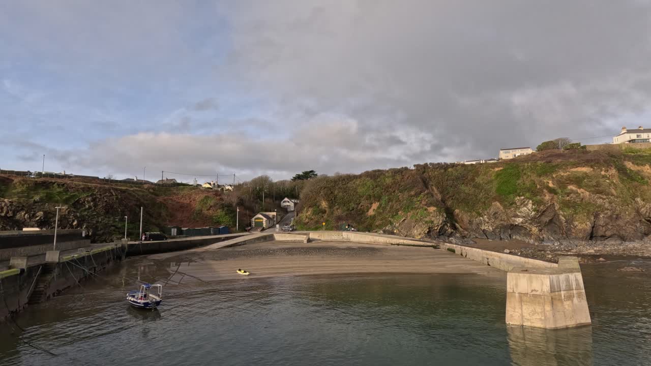 Molen ved Tramore, Irland, beskyttet af et betonet bølgebrydere, gylden