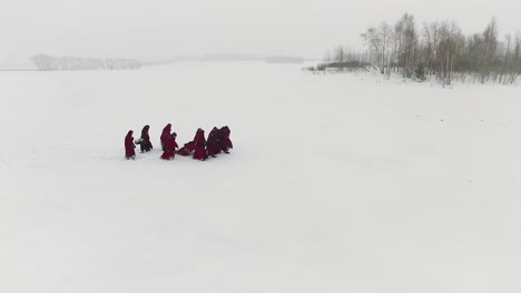 people in red robes on a snowy landscape