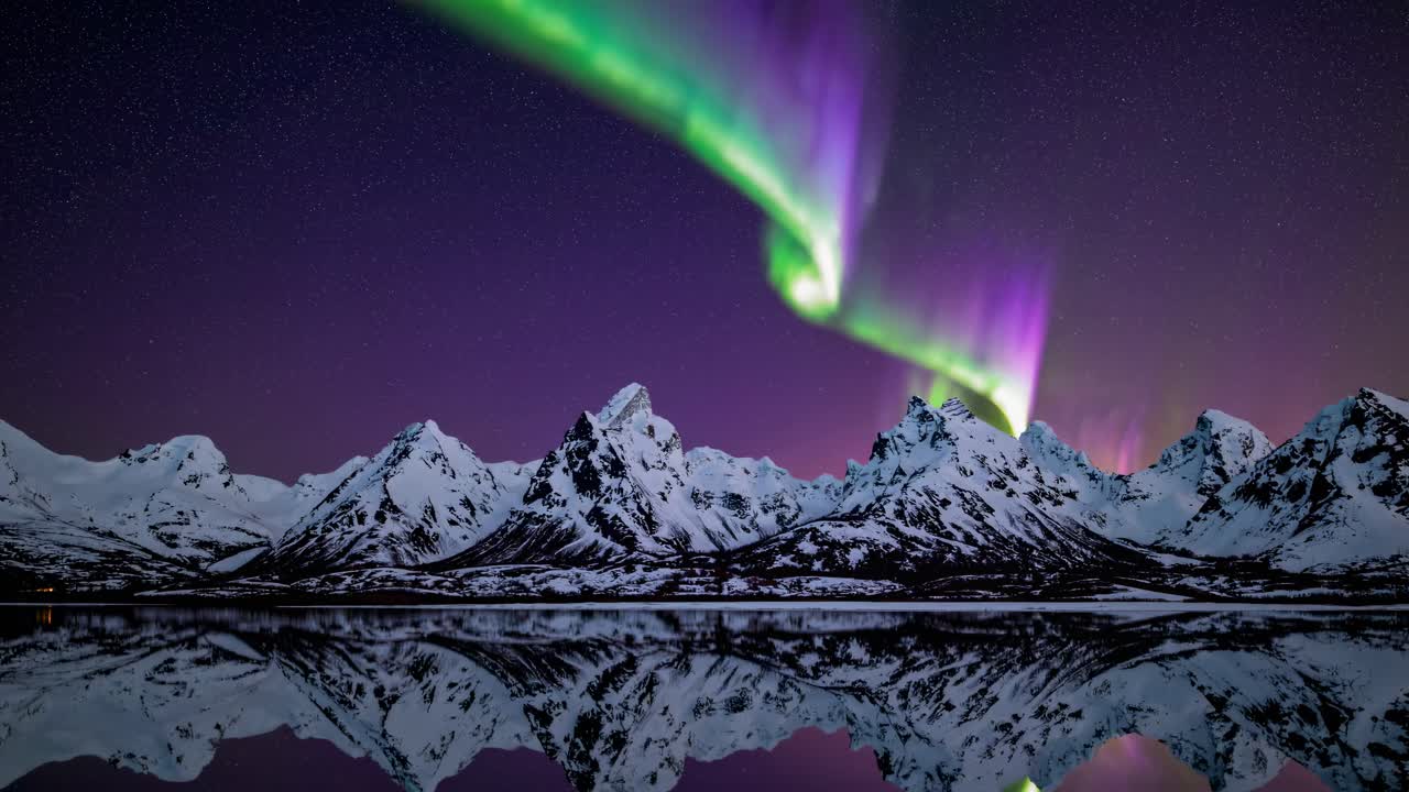 A mesmerizing video capturing the Northern Lights dancing over snowy mountains