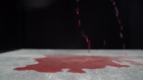 spilling red beverage and splatters on grey table black background